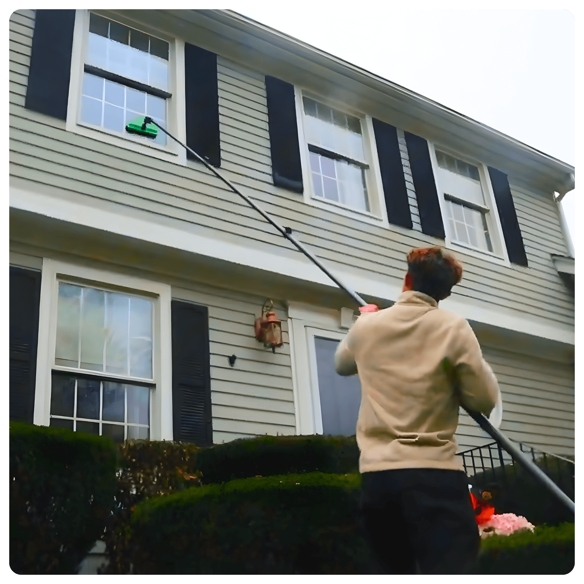 Technician cleaning a second-story exterior window with a pure-water pole